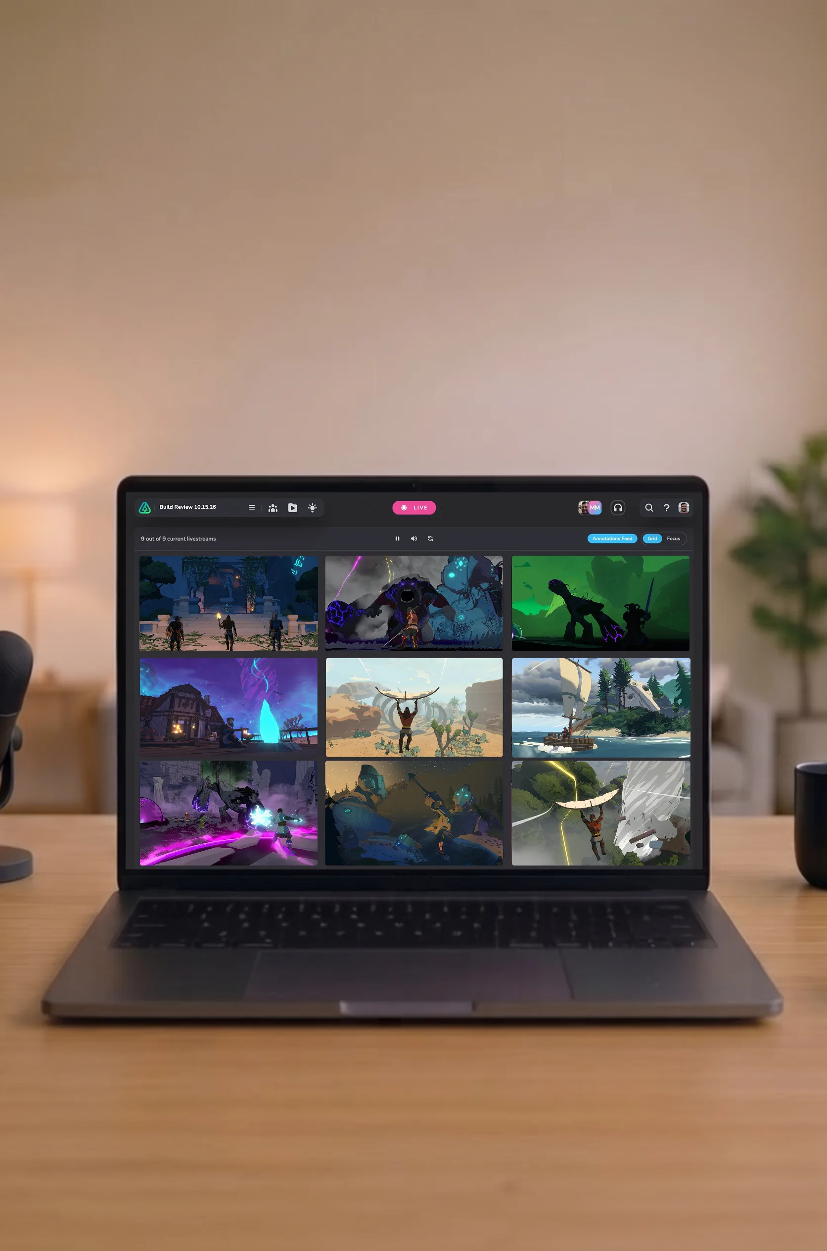 A creator's desk with a laptop showing the LIVE AWARE Livestream Gallery View — a grid of nine playtester streams running live — with a microphone, headphones, and a coffee mug